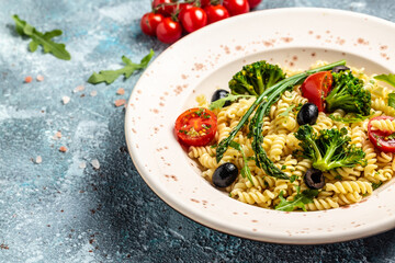 Bowl of fusili pasta salad with fresh vegetables. Greek Salad with pasta. Food recipe background. Close up. top view