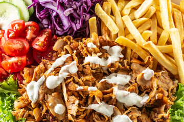 Top view closeup of Turkish grilled kebab with homegrown vegetables, salty fries and tasty dressing