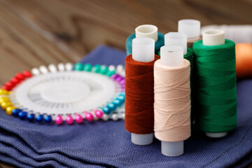 Threads and sewing accessories on brown wooden table