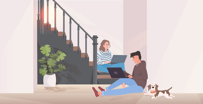 man woman using laptops couple sitting on staircase spending time together modern hallway interior