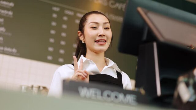 Customer paying with qr code on smartphone screen NFC payment technology at coffee shop.Midsection of female staff showing contactless menu QR code on digital mobile.