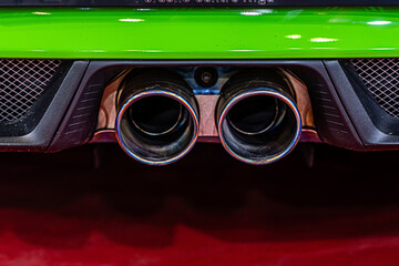 close-up of modern sporty car dual exhaust pipes, vehicle smog polluting the air