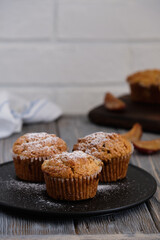 Gentle and fragrant mafins with frozen plum on a black plate on the old wooden table