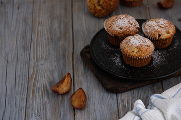 Gentle and fragrant mafins with frozen plum on a black plate on the old wooden table