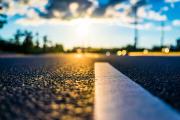 Sunset after rain, the empty highway. Close up view from the level of the solid line
