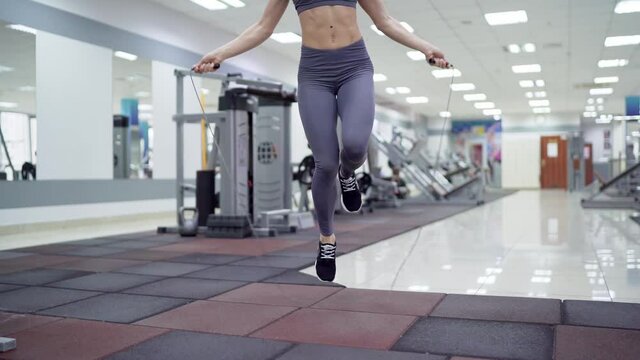 Young woman with jumping rope in fitness center