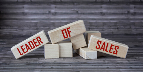 Business concept. On a wooden background and on wooden blocks -LEADER OF SALES