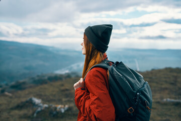 woman jacket hats looking at the mountain in the distance blue sky clouds Model backpack