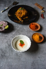 Leaf on yogurt with use of selective focus with cooked food and condiments in the background.