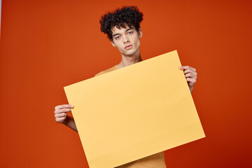 guy with curly hair island in hands advertising red background