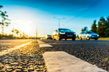 Sunset in the country, the stream of cars passing by on the highway. Wide angle view of the level of the dividing line