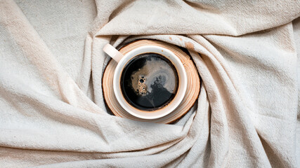 closeup black coffee cup put on linen fabric. top view