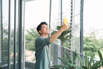 Young asian man taking a selfie on balcony