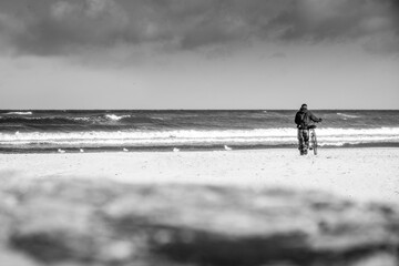 Fototapeta na wymiar person walking on the beach with a bike