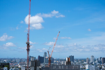 Fototapeta na wymiar Building construction with crane against blue sky background, Steel frame structure,