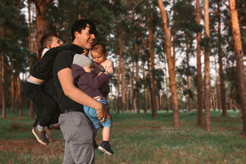 A large family on vacation. Happy father with three children at a picnic in the forest.
