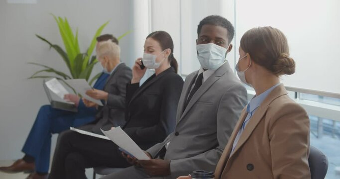 Diverse business people waiting for job interview with face mask