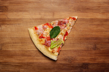slice of hot fresh pizza on a wooden background. Top view, flat lay
