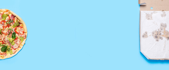pizza and empty open pizza packaging on blue background. Top view, flat lay. Banner