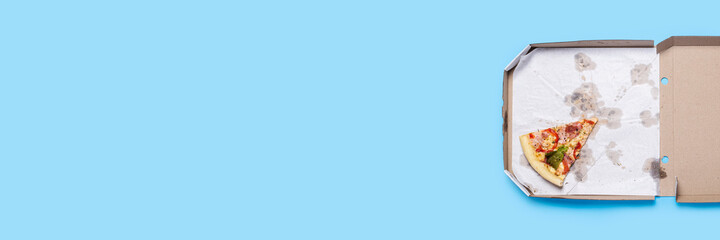 slice of hot fresh pizza lies in a cardboard package on a blue background. Top view, flat lay....