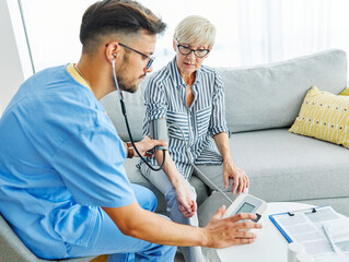 Obraz premium nurse doctor senior care caregiver help check exam blood pressure check pulse retirement home stethoscope nursing elderly man woman health
