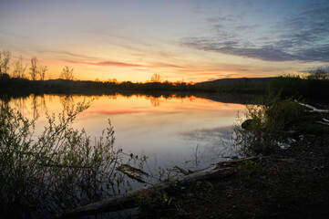 Naklejka na ściany i meble Beautiful Sunset Scenery on small lake with reflection of the sky