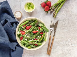 A healthy and delicious salad made from fresh strawberries, green asparagus, feta cheese with vegetable leaves. Vegetarian seasonal food. Detox diet meal. - Powered by Adobe