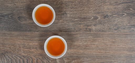 Fototapeta na wymiar two white small tea bowls on wooden table, above panoramic shot