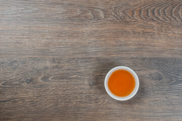 white small tea bowl on wooden table, above minimalistic shot