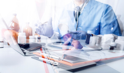 Male doctor sitting at table and writing on a document report in hospital office. Medical healthcare staff and doctor service.