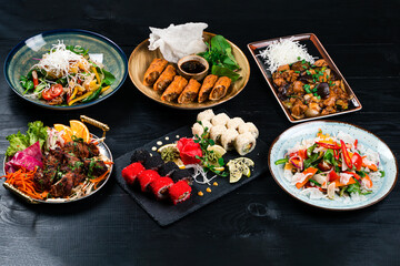 Asian food cooking. Wok, noodles and vegetables salad and chopsticks on dark rustic background