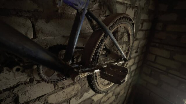 Dark closet. An old children's bicycle is gathering dust in the attic. Father's old-fashioned bicycle. Bike from the past. Cobwebs covered the children's bike. Growing up.