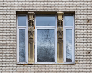 Vintage architecture classical facade in Art Nouveau style front view. One window modern plastic frame historical columns with female heads