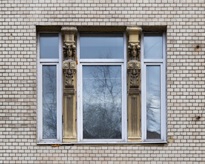 Fototapeta premium Vintage architecture classical facade in Art Nouveau style front view. One window modern plastic frame historical columns with female heads