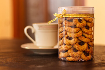 Selected Focus image of cookies in a jar with a blurred cup behind