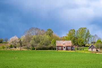 Old cottage in the countryside with dark clouds on the sky