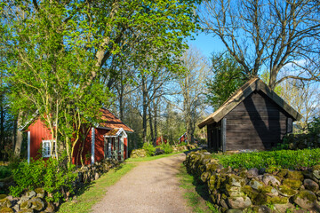 Idyllic red cottage and a shed at a dirt road