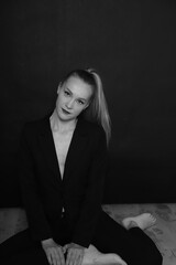 Black and white photo of a fashion girl on a black background in black clothes light skin