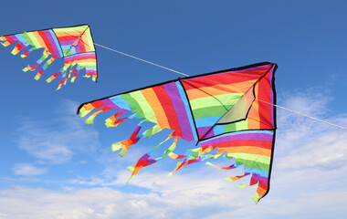 two big colorful kites flying high in the sky, symbol of freedom and lightheartedness