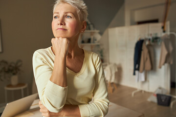 Mature people and aging concept. Indoor shot of bored thoughtful retired female in casual clothing...