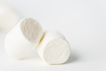 Fototapeta na wymiar White marshmallows on a light background. Selective focus.