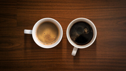 closeup black coffee cup on wood board. top view