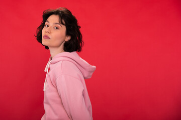 Portrait of young sexy self-confident brunette woman in trendy hipster hoodie posing on isotaled...