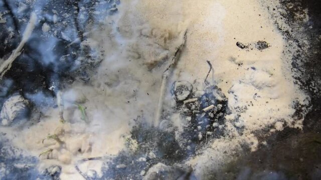 Abstract view of drinkable erupting fresh water source in nature. Natural crystal clear water comes from underground and makes the sand boil. Boiling sand pure water stream in nature