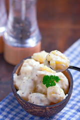 gnocchi in coconut sauce, served in a coconut bowl