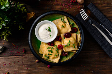 homemade ravioli with fresh cherries in bowl on a dark rustic table with fresh berries
