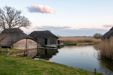Boat houses at Hickling Broad in the Norfolk Broads, UK.