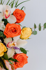 Ceramic vase with roses, cymbidium, alstroemeria and greenery.