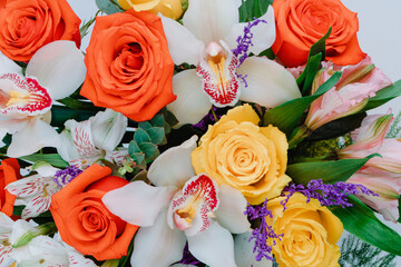 Ceramic vase with roses, cymbidium, alstroemeria and greenery.