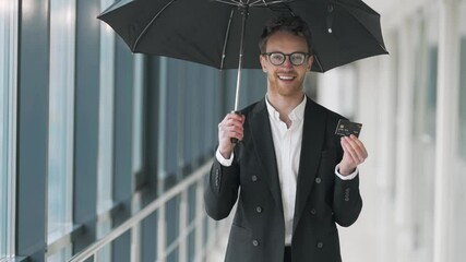 Portrait of a happy business man with an umbrella and a plastic briefcase in his hands - Powered by Adobe